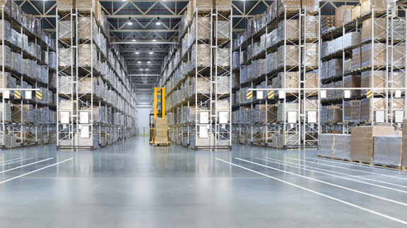 Huge distribution warehouse with high shelves and loaders. Bottom view.